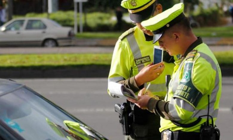 Agente de tránsito verificando el número IMEI de un teléfono móvil.